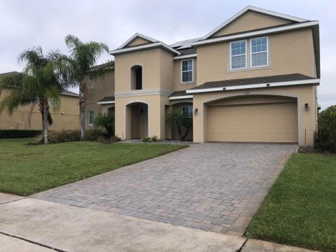 Clean driveway and well-maintained house exterior after pressure washing services in Orlando, FL.